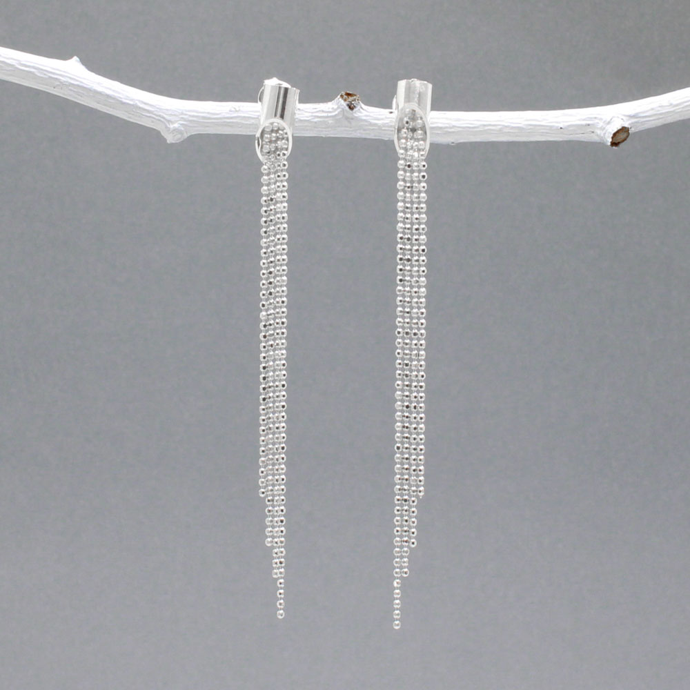 Áine - Cylinder with Chains Silver Earrings - Stud Design: Four chains of different lengths cascading from the center of the cylinder Cylinder Diameter: 4 MM Total Length: 61 MM from top to bottom Material: Sterling silver with a highly polished finish Fastening: Sterling silver friction post