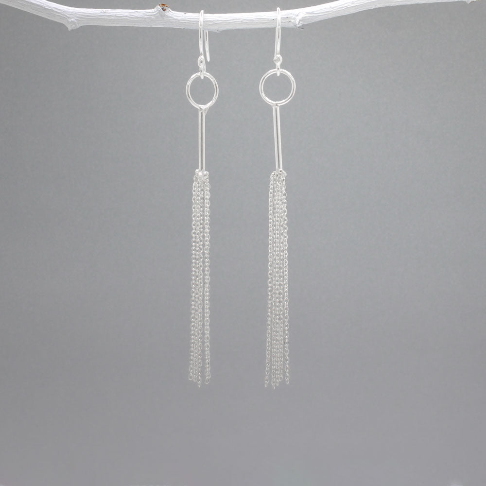 Áine - Tessel Silver Earrings - Dangle Design: Multi cascading chains on skinny tube, mimicking a tessel Style: Silver Earrings - Dangle Material: Sterling silver Fastening: Sterling silver French wire Length: 85 MM from top of French wire Features: Lightweight, whimsical Measurements: Tube thickness: 1.2 MM Hoop diameter: 9 MM