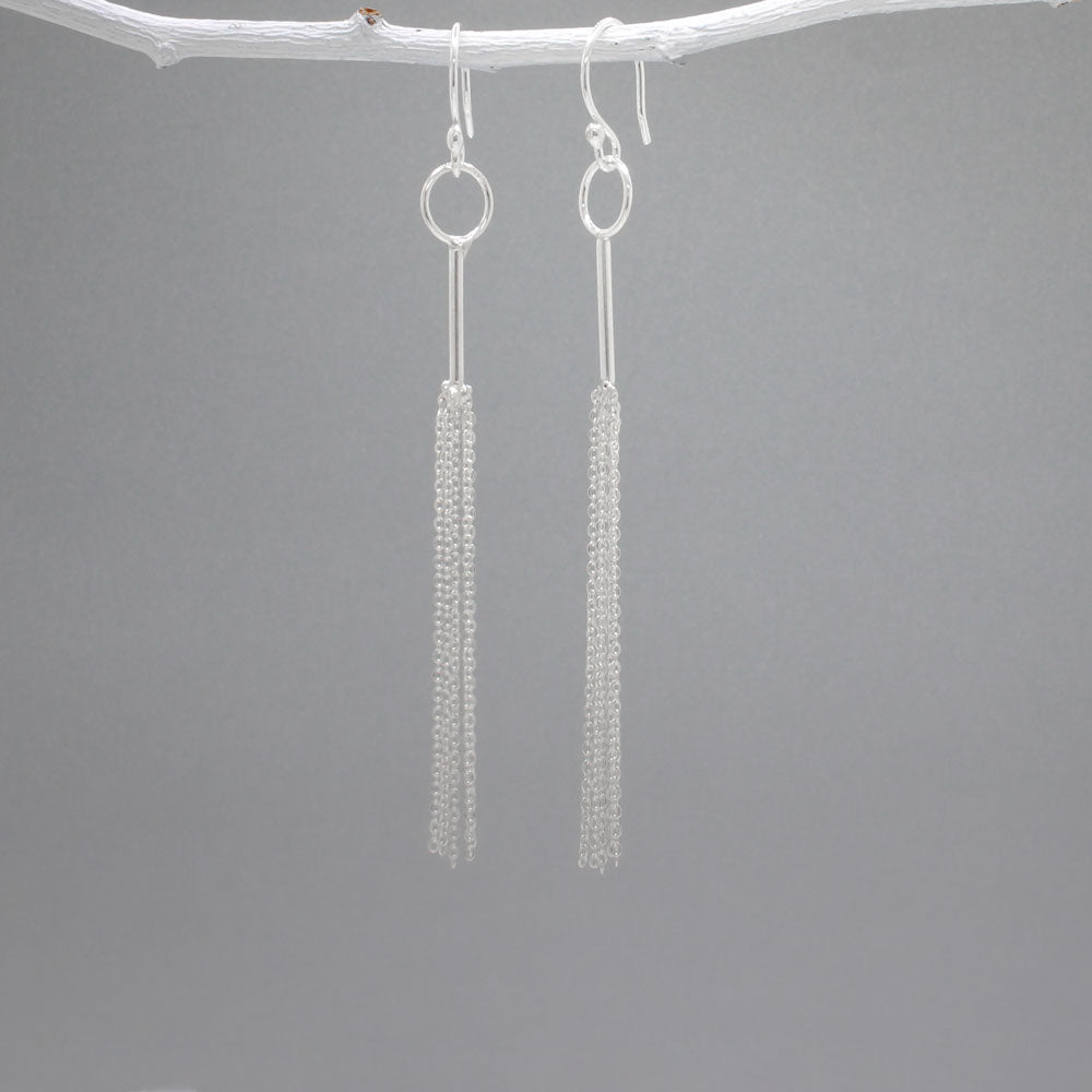 Áine - Tessel Silver Earrings - Dangle Design: Multi cascading chains on skinny tube, mimicking a tessel Style: Silver Earrings - Dangle Material: Sterling silver Fastening: Sterling silver French wire Length: 85 MM from top of French wire Features: Lightweight, whimsical Measurements: Tube thickness: 1.2 MM Hoop diameter: 9 MM