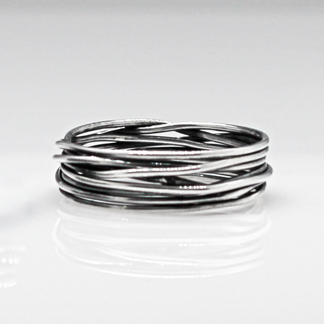 Aran - Lasso S Oxidised Silver Ring. Inspired by lasso rope designs, this piece offers a unique twist to your style. Crafted with oxidized sterling silver and featuring a comfortable 6mm band width, it's perfect for wearing solo or stacking with other rings to make a statement.