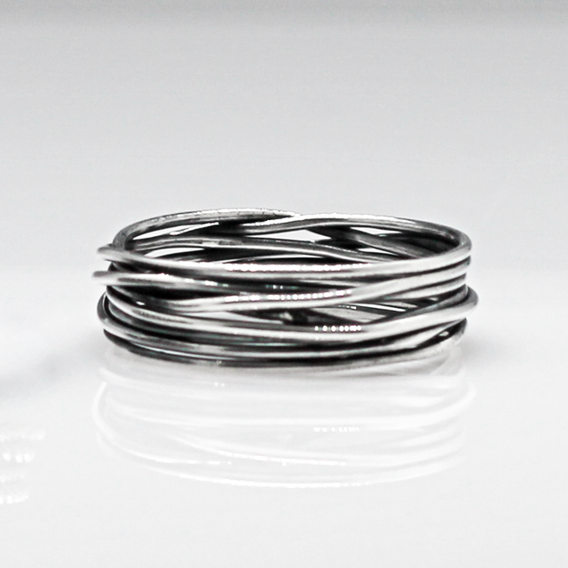 Aran - Lasso S Oxidised Silver Ring. Inspired by lasso rope designs, this piece offers a unique twist to your style. Crafted with oxidized sterling silver and featuring a comfortable 6mm band width, it's perfect for wearing solo or stacking with other rings to make a statement.