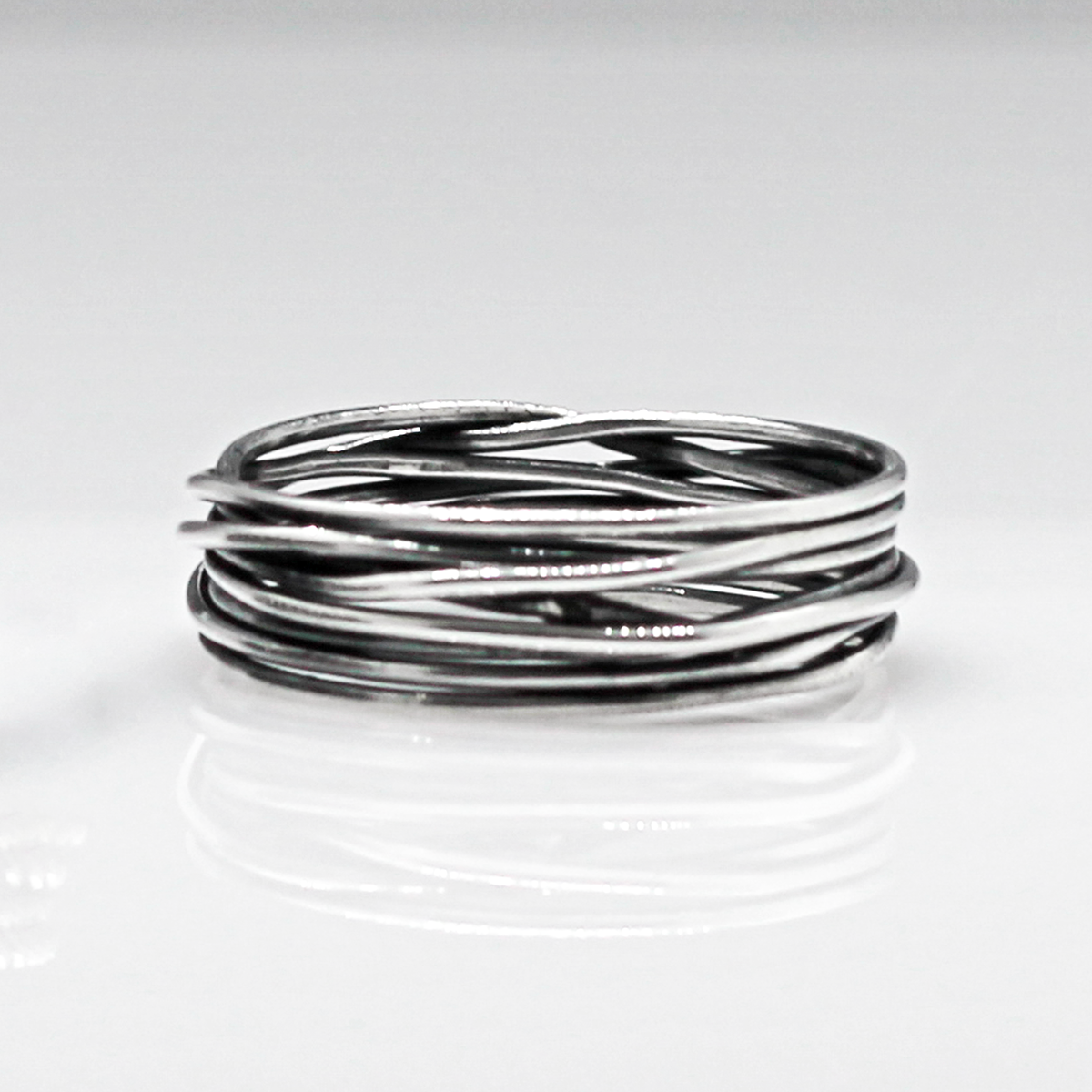 Aran - Lasso S Oxidised Silver Ring. Inspired by lasso rope designs, this piece offers a unique twist to your style.  Crafted with oxidized sterling silver and featuring a comfortable 6mm band width, it's perfect for wearing solo or stacking with other rings to make a statement.