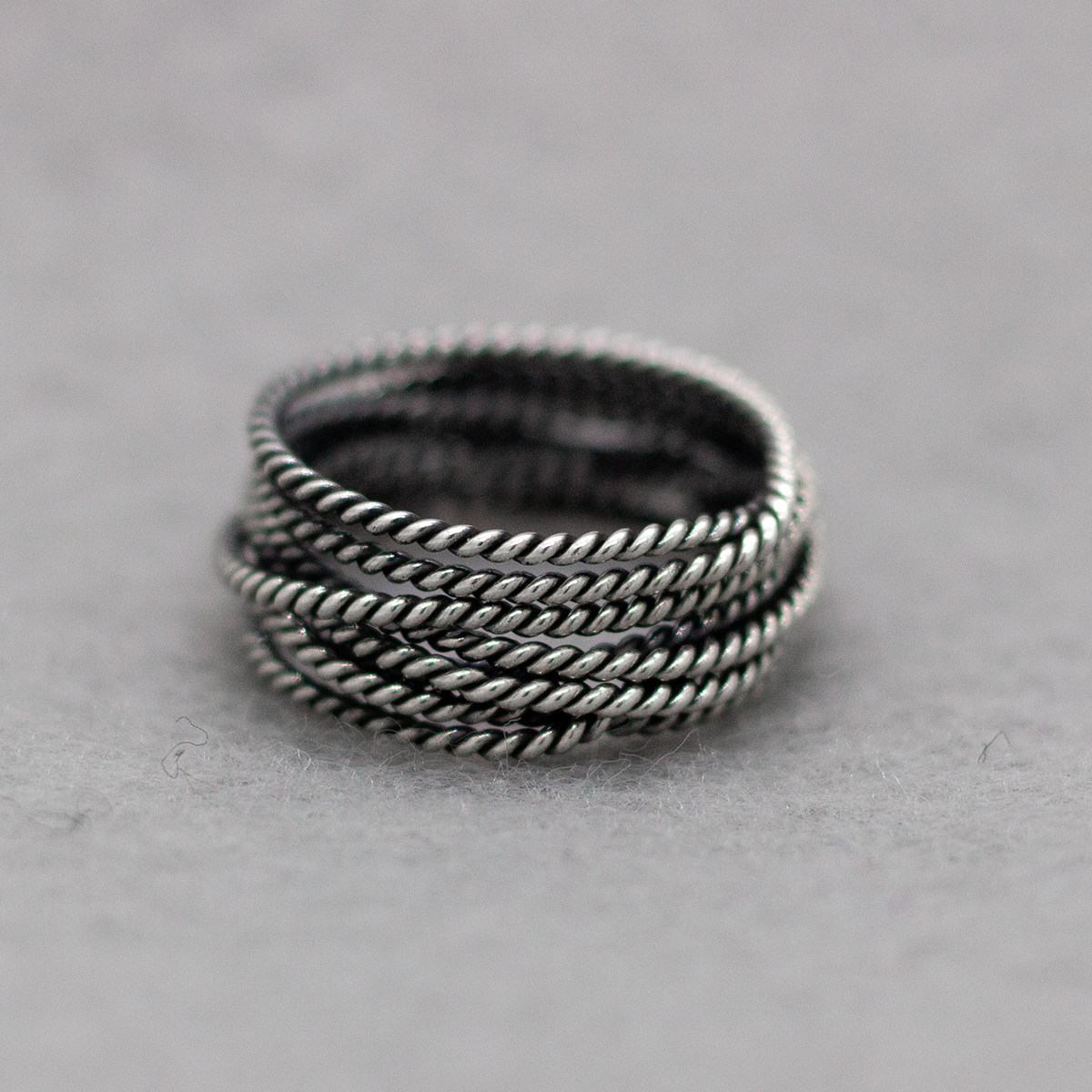 Aran - Twisted Lasso Oxidised Silver Ring. Inspired by the intricate twists of lasso rope designs, this piece adds a unique flair to your style.  Crafted from oxidized sterling silver and featuring a comfortable 7mm band width, it's ideal for wearing alone or stacking with other rings for a bold statement. Kisnale.