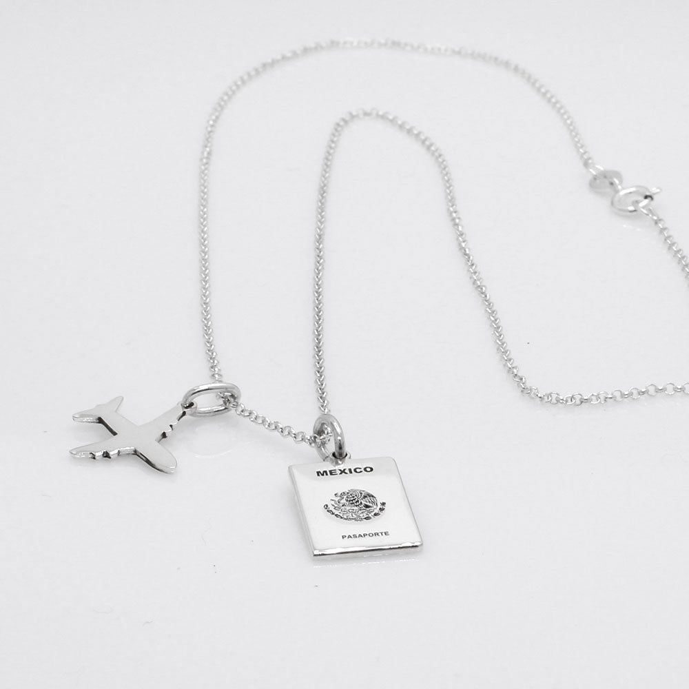 Our Mexican Passport Mini Replica Silver Pendant captures the intricate details of a Mexican passport cover, meticulously crafted from sterling silver with a high-polished finish. Dimensions: Passport: 10mm wide by 14mm high; Airplane: 14mm wide by 14mm high. Bail: Fits up to a 2.5mm chain for versatile wear. Chain: Includes a 1.4mm sterling silver belcher Rolo chain, available in various lengths.