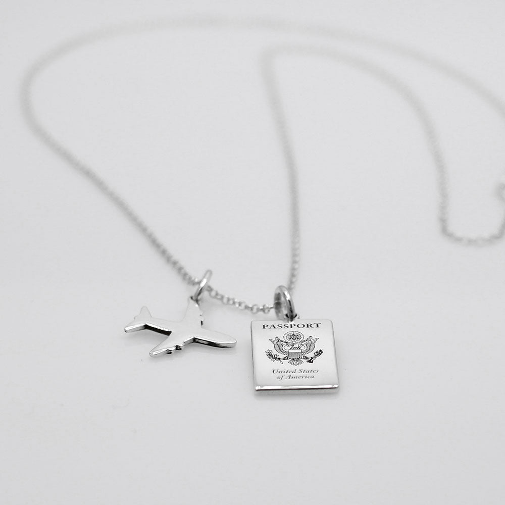 Our US Passport Mini Replica Silver Pendant captures the intricate details of a US passport cover, meticulously crafted from sterling silver with a high-polished finish. Dimensions: Passport: 10mm wide by 14mm high Airplane: 14mm wide by 14mm high Bail: Fits up to a 2.5mm chain for versatile wear. Chain: Includes a 1.4mm sterling silver belcher Rolo chain, available in various lengths.