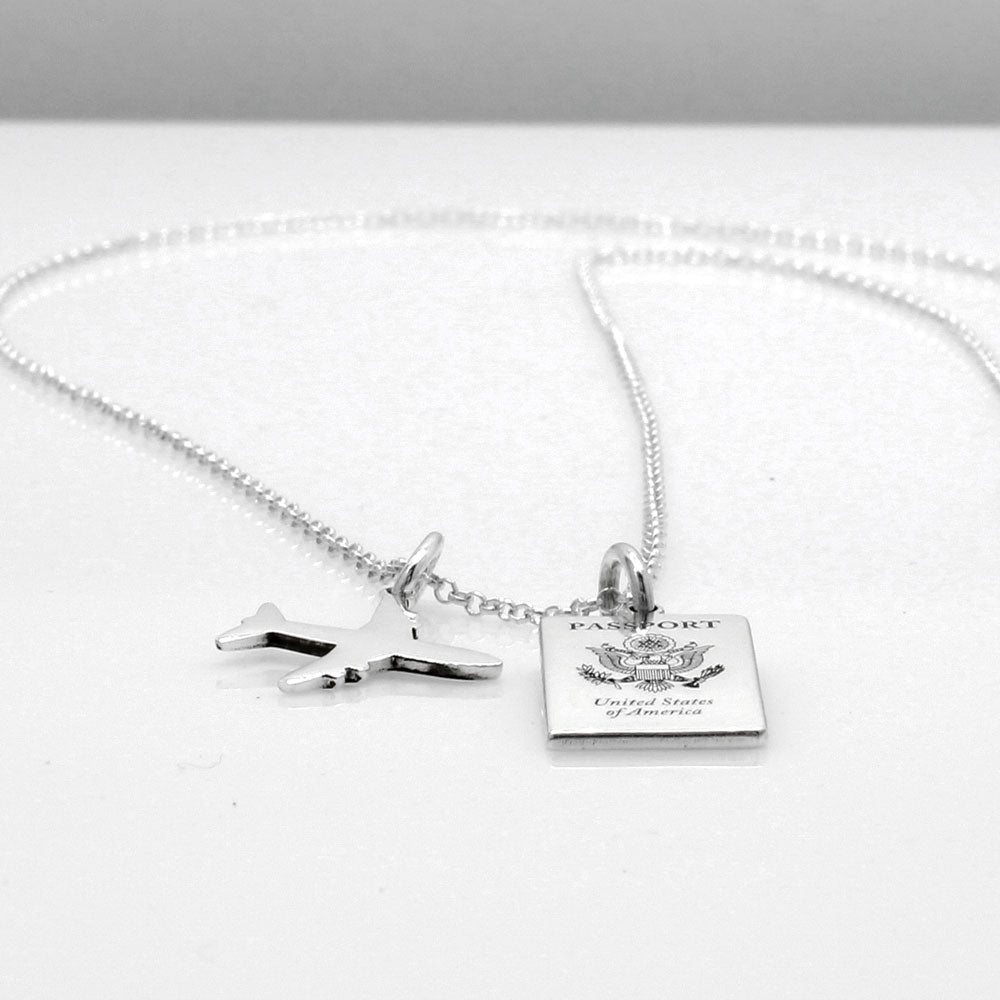 Our US Passport Mini Replica Silver Pendant captures the intricate details of a US passport cover, meticulously crafted from sterling silver with a high-polished finish. Dimensions: Passport: 10mm wide by 14mm high Airplane: 14mm wide by 14mm high Bail: Fits up to a 2.5mm chain for versatile wear. Chain: Includes a 1.4mm sterling silver belcher Rolo chain, available in various lengths.