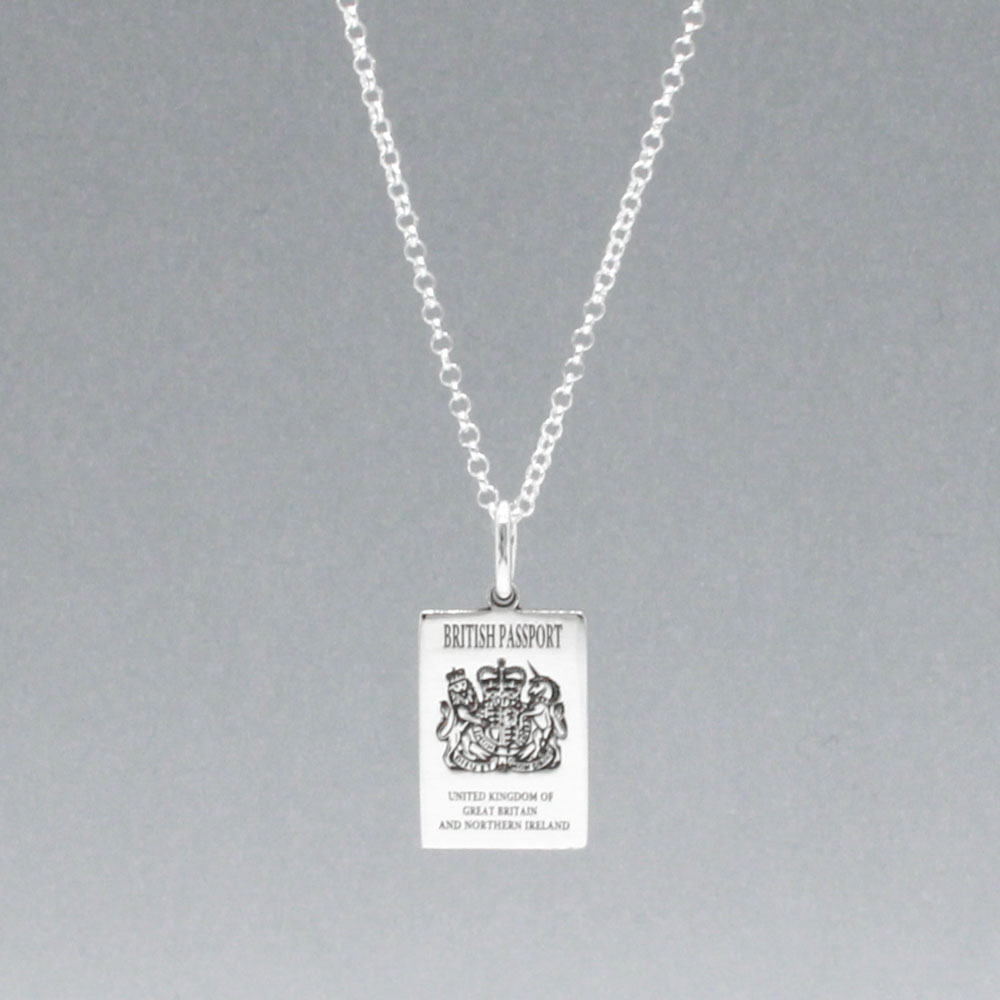 Our British Passport Mini Replica Silver Pendant captures all the intricate details of a British passport cover. Meticulously crafted from sterling silver, it boasts a dazzling high-polished finish. Dimensions: Passport: 10mm wide by 14mm high Airplane: 14mm wide by 14mm high Bail: Fits up to a 2.5mm chain for versatile wear. Chain: Includes a 1.4mm sterling silver belcher Rolo chain, available in various lengths to suit your style preference.