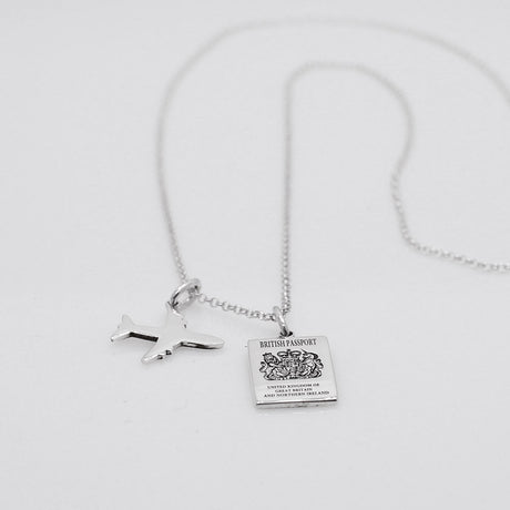 Our British Passport Mini Replica Silver Pendant captures all the intricate details of a British passport cover. Meticulously crafted from sterling silver, it boasts a dazzling high-polished finish.  Dimensions: Passport: 10mm wide by 14mm high Airplane: 14mm wide by 14mm high Bail: Fits up to a 2.5mm chain for versatile wear. Chain: Includes a 1.4mm sterling silver belcher Rolo chain, available in various lengths to suit your style preference.