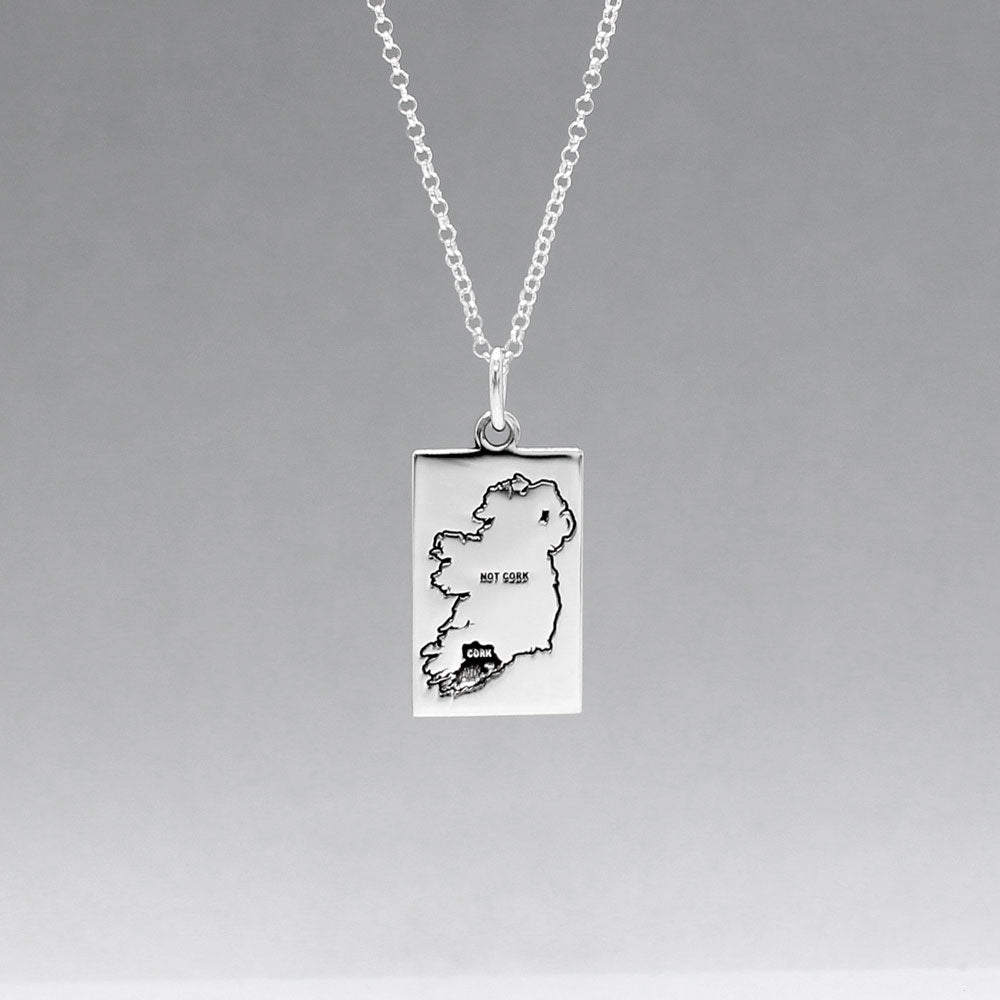 Celebrate Cork with our Eire - Cork & Not Cork Silver Pendant. Design: Features a map highlighting Co. Cork with a light oxidized finish, contrasting with the rest of Ireland. Dimensions: 13mm wide by 20mm long. Materials: Handmade from sterling silver. Chain: Includes a 1.4mm sterling silver Rolo chain with a spring clasp. Choose your preferred length during checkout.