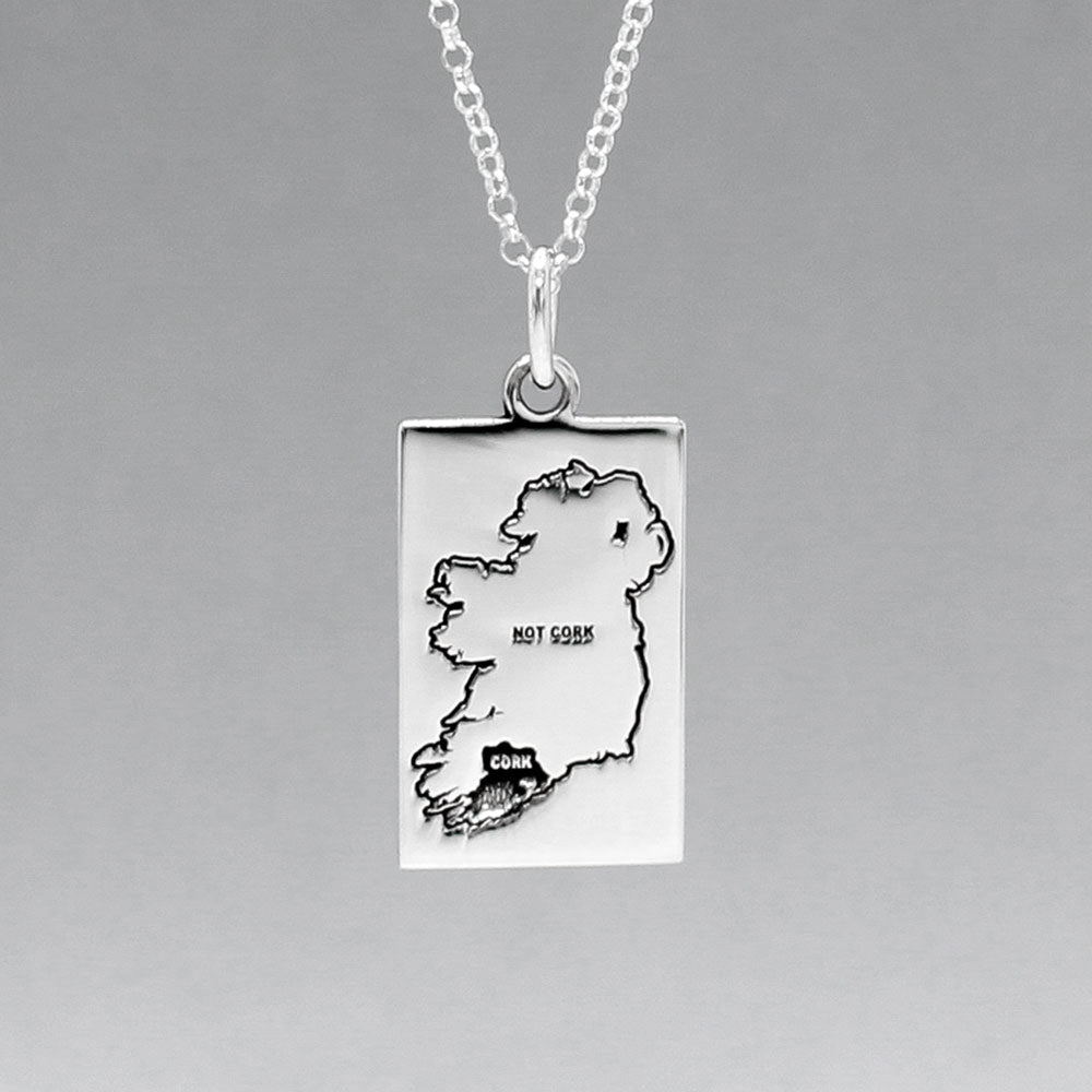Celebrate Cork with our Eire - Cork & Not Cork Silver Pendant. Design: Features a map highlighting Co. Cork with a light oxidized finish, contrasting with the rest of Ireland. Dimensions: 13mm wide by 20mm long. Materials: Handmade from sterling silver. Chain: Includes a 1.4mm sterling silver Rolo chain with a spring clasp. Choose your preferred length during checkout.