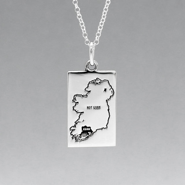Celebrate Cork with our Eire - Cork & Not Cork Silver Pendant. Design: Features a map highlighting Co. Cork with a light oxidized finish, contrasting with the rest of Ireland. Dimensions: 13mm wide by 20mm long. Materials: Handmade from sterling silver. Chain: Includes a 1.4mm sterling silver Rolo chain with a spring clasp. Choose your preferred length during checkout.