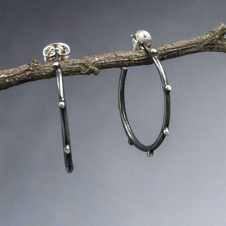 Add a unique touch to your collection with the Firmament - Aloe Oxidised Hoop Silver Earrings. Crafted from high-quality .925 sterling silver, these earrings feature a stylish dot design that catches the eye. Croí Kinsale Jewellery, located in the heart of Kinsale, to explore this stunning piece and more!