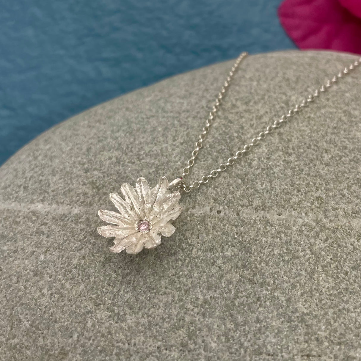 Silver Poppy Seed Pendant with Pink Tourmaline! Diameter: 14mm Centre Stone: Pink faceted tourmaline Finish: Casted with a matte finish Chain: Silver rolo chain included, select your preferred length below A delicate and charming piece. Kathleen Holland Jewellry