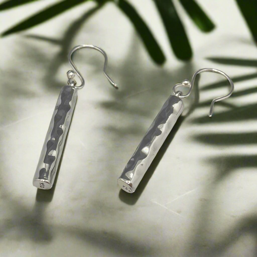 Moíneir Bamboo Stick Silver Earrings, a stunning fusion of modern design and artisanal craftsmanship. Handcrafted from .950 sterling silver, these dangle earrings feature a beautiful hammered texture that catches the light, adding a unique and eye-catching element to your look.