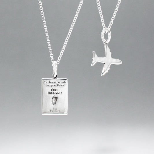 Irish Passport Replica Mini Silver Pendant with Mini Airplane Charm Pendant by Croí Kinsale Jewellery.  The passport measures 10 millimeters wide by 14 millimeters high, while the airplane charm measures 14 millimeters wide by 14 millimeters high. The bail fits up to a 2.5 mm chain, offering versatility for different chain sizes. Whether you gift it to a wanderer or keep it as a timeless heirloom, this pendant is a symbol of Irish pride and wanderlust.