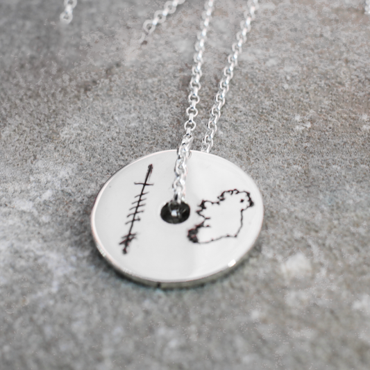 EIRE - Ogham Grá &amp; Eire Map Disc Silver Pendant embodies the sentiment of "I ❤️ Ireland" with intricate Ogham script spelling out the word Grá (Love). It showcases a dazzling high-polished finish, accompanied by a detailed outline of the map of Ireland.