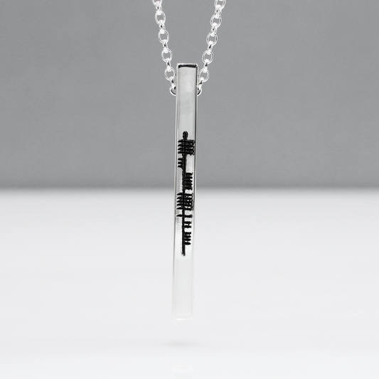 Our EIRE - Ogham Sláinte High Polished Bar Silver Pendant elegantly showcases intricate Ogham script spelling out the Irish word "Sláinte," a traditional toast meaning "health" in English. This word is often used when raising a glass in celebration or to wish good health to others.