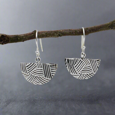 Transform your style with the Saha DECO Abanico Oxidised Silver Earrings. Inspired by Art Deco elegance, these handcrafted earrings feature a whimsical fan-shaped design with a weaved embossed pattern. The oxidised finish highlights the intricate details, creating a striking contrast with the polished silver. Flirty yet timeless, these earrings are perfect for everyday wear or a touch of glamour on special occasions. Ireland jewellery