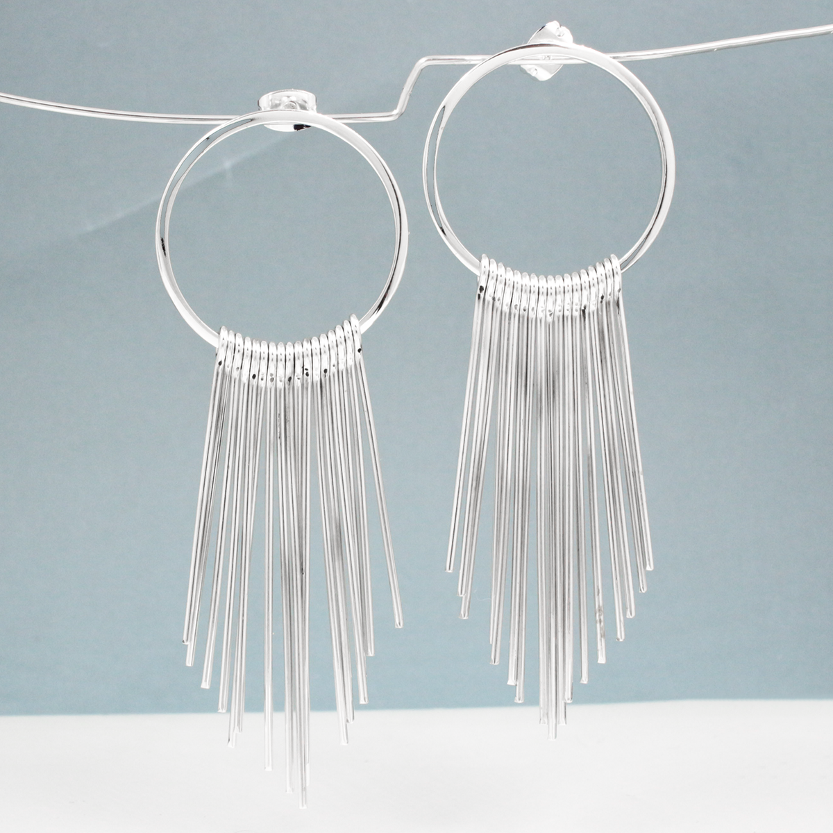 Saha - RADA Cascade Long Hoop Silver Earrings - Stud. These earrings command attention with their impressive dimensions: the hoop measures 28mm in diameter by 1.5mm thick, or roughly 1 1/16 inches by 1/16 inches thick. Extending gracefully at 75mm from the top of the ear wire, they make a striking statement.