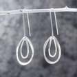 Add movement and elegance to your jewellery collection with the Saha Double Spinning Asymmetric Organic Oval Droplet Silver Earrings. These handcrafted sterling silver earrings feature a unique design of two spinning, asymmetric oval droplets, creating a dynamic and organic look. The high-polished finish enhances their modern charm, making them a versatile accessory for any occasion. Ireland jewellery