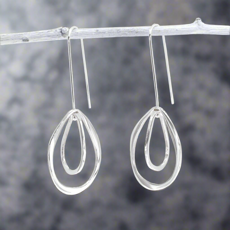 Add movement and elegance to your jewellery collection with the Saha Double Spinning Asymmetric Organic Oval Droplet Silver Earrings. These handcrafted sterling silver earrings feature a unique design of two spinning, asymmetric oval droplets, creating a dynamic and organic look. The high-polished finish enhances their modern charm, making them a versatile accessory for any occasion. Ireland jewellery