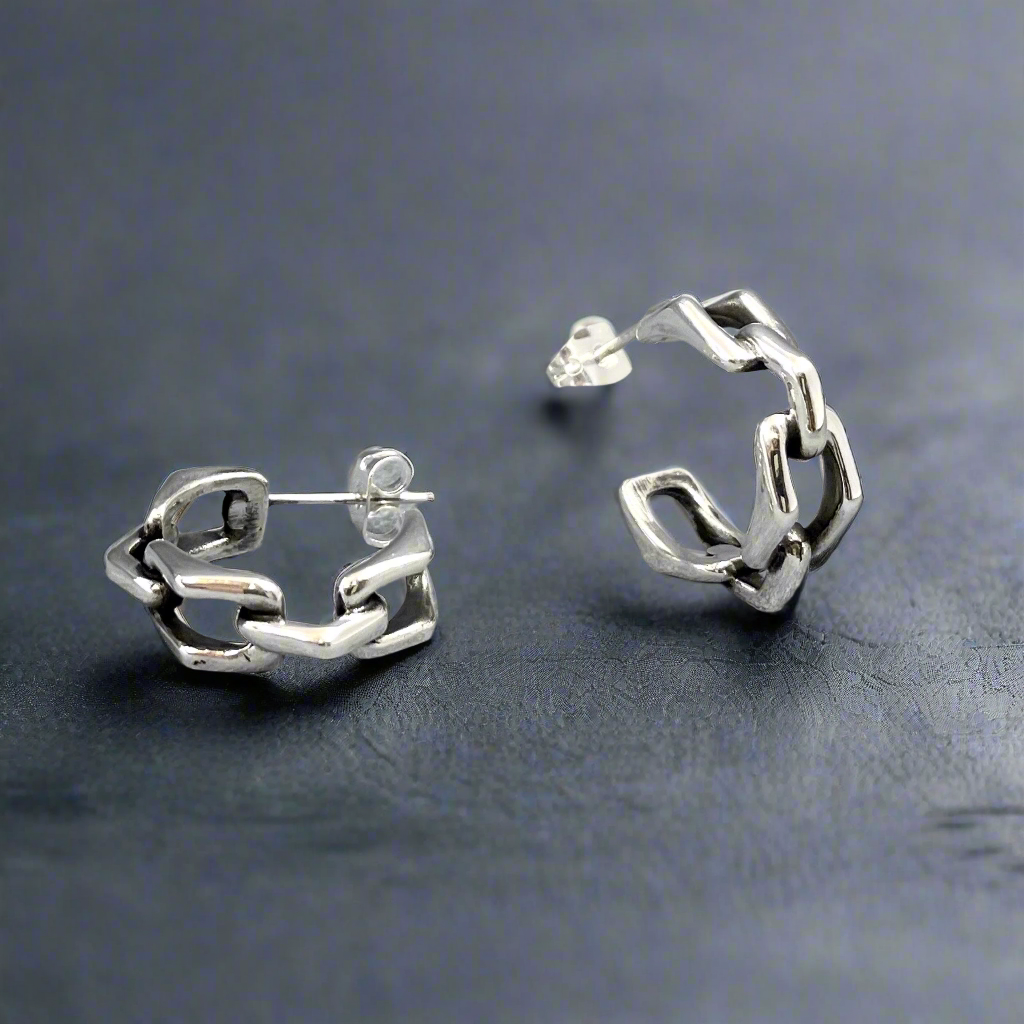 Express your style with the Saha Small Bridge Chain Hoop Silver Earrings. Handcrafted from sterling silver, these hoops feature a design inspired by triangulated chain links, blending modern sophistication with everyday wearability. Their compact size and sleek finish make them a versatile addition to your jewellery collection. Silver jewellery online ireland