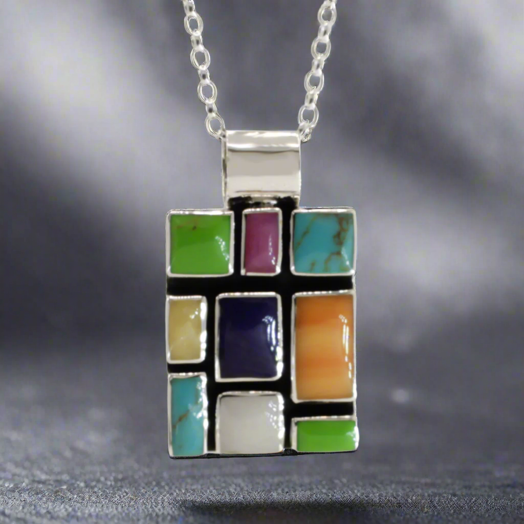 Sleveen Rectangle With Multi-Coloured-Mosaic-Resin-Pendant Ireland jewellery silver. Sleveen's Rectangle with Multi-Coloured Mosaic Resin Silver Pendant is an exquisite piece of jewellery that makes a bold statement. Inspired by the lively and picturesque hues of Kinsale’s iconic houses, this pendant features a striking mosaic design set in .925 sterling silver.
