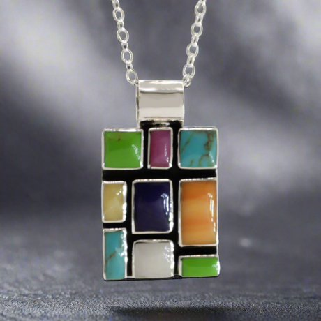 Sleveen Rectangle With Multi-Coloured-Mosaic-Resin-Pendant Ireland jewellery silver. Sleveen's Rectangle with Multi-Coloured Mosaic Resin Silver Pendant is an exquisite piece of jewellery that makes a bold statement. Inspired by the lively and picturesque hues of Kinsale’s iconic houses, this pendant features a striking mosaic design set in .925 sterling silver.