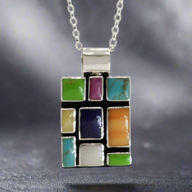 Sleveen Rectangle With Multi-Coloured-Mosaic-Resin-Pendant Ireland jewellery silver. Sleveen's Rectangle with Multi-Coloured Mosaic Resin Silver Pendant is an exquisite piece of jewellery that makes a bold statement. Inspired by the lively and picturesque hues of Kinsale’s iconic houses, this pendant features a striking mosaic design set in .925 sterling silver.