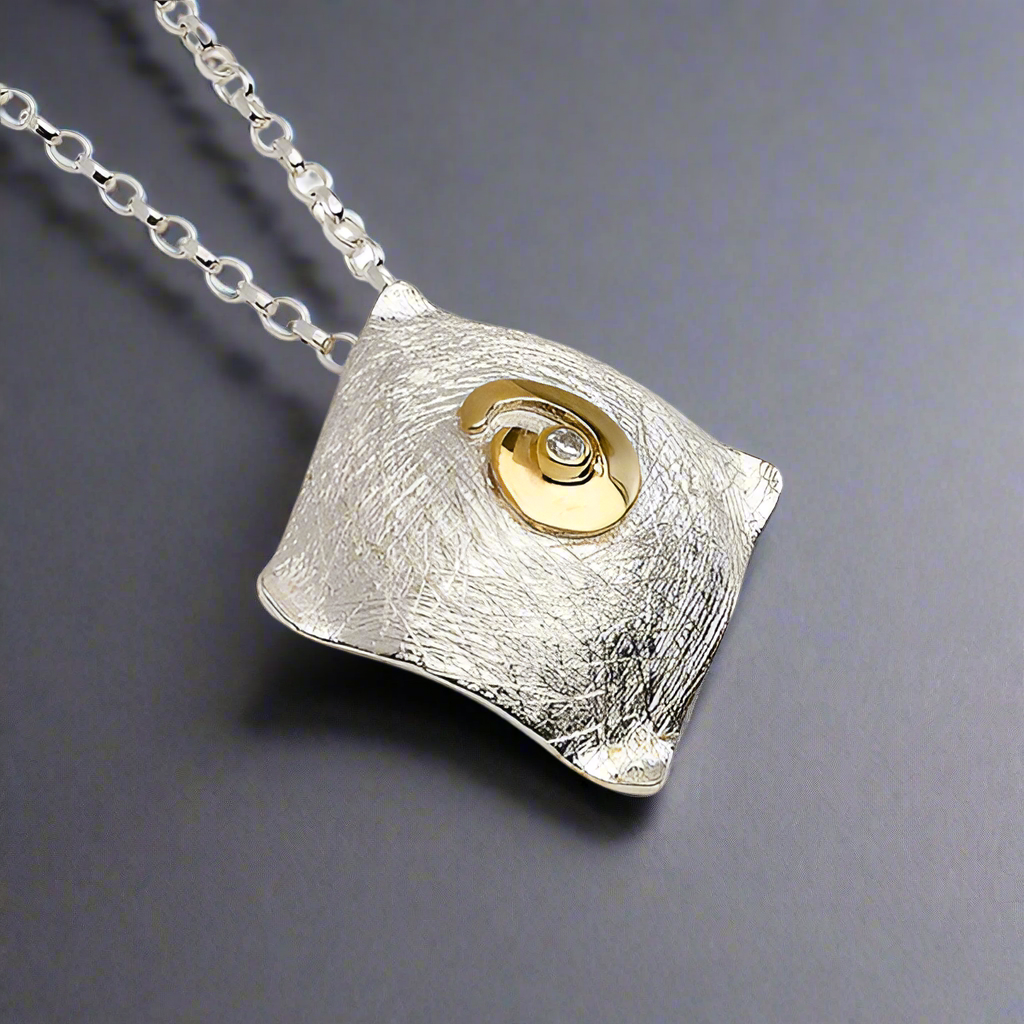 Celebrate Celtic heritage with a modern twist in this Celtic Spiral Pendant by renowned Irish designer Garrett Mallon. Inspired by one of the oldest Celtic symbols, believed to represent the sun or ethereal energy, this piece combines 18 carat gold vermeil and sterling silver, showcasing Garrett's signature style of blending textures and metals. Perfect for everyday wear! Croí Kinsale Jewellery