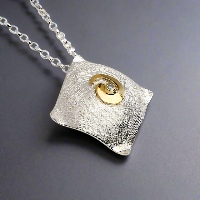 Celebrate Celtic heritage with a modern twist in this Celtic Spiral Pendant by renowned Irish designer Garrett Mallon. Inspired by one of the oldest Celtic symbols, believed to represent the sun or ethereal energy, this piece combines 18 carat gold vermeil and sterling silver, showcasing Garrett's signature style of blending textures and metals. Perfect for everyday wear! Croí Kinsale Jewellery