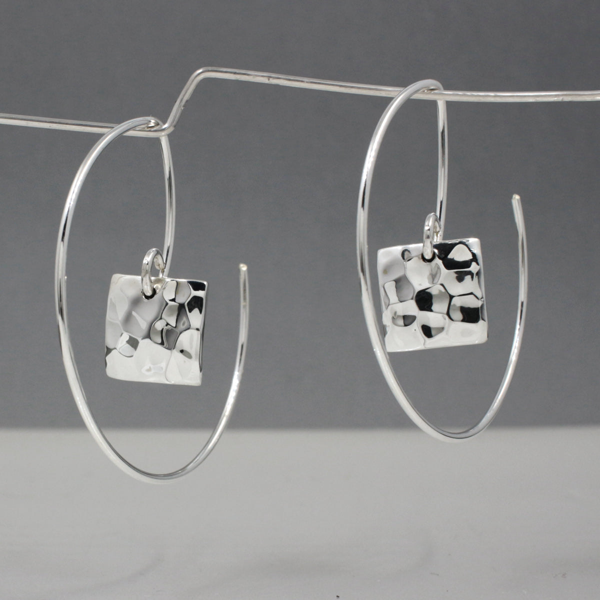 Artemis - Small Square Hammered Reverse Hoop Silver Earrings Curated and designed by Emilio Sotelo Jewelry for Croi Kinsale Jewellery in Kinsale West Cork Ireland Europe. Find exceptional handmade silver and gold jewellery at affordable prices for birthday gifts and Christmas presents. Handcrafted Silver jewelry. The best affordable jewellery