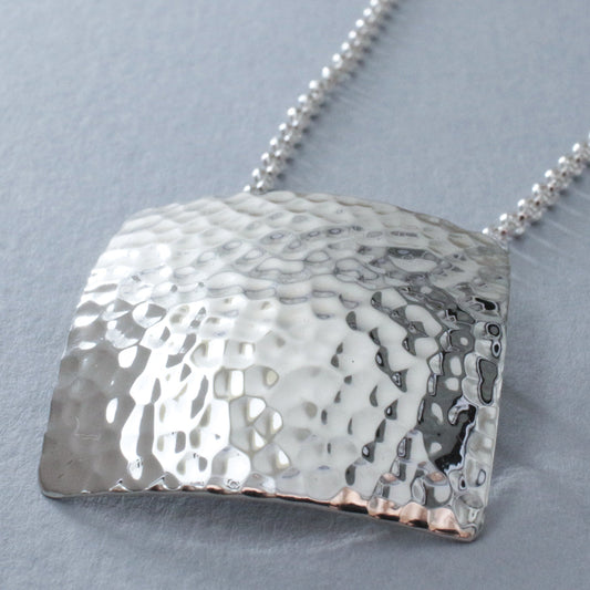 Artemis - Square Hammered Silver Pendant Curated and designed by Emilio Sotelo Jewelry for Croi Kinsale Jewellery in Kinsale West Cork Ireland Europe. Find exceptional handmade silver and gold jewellery at affordable prices for birthday gifts and Christmas presents. Find Irish designers and makers. Beautiful jewellery shop located in Kinsale, Co. Cork.