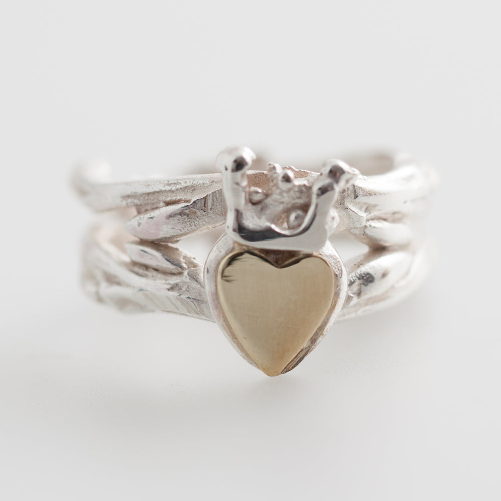 Double Claddagh Ring by Kathleen Holland Jewellery  Design: Organic Claddagh inspired by twigs and Irish coral Material: Solid sterling silver cast with a 9ct gold heart surface Finish: Highly polished Band: Measures 7.5mm in width Centre: Heart and crown measure 13mm long A beautifully crafted piece, blending tradition with nature's elegance. Perfect for expressing love, loyalty, and friendship.