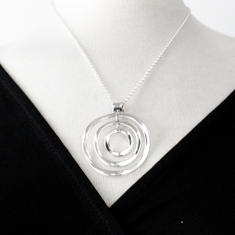 AYA Multi Circle Silver Pendant: a timeless symbol of elegance and versatility. With a substantial 42mm diameter and a length of 48mm from the top of the bail.  Crafted from .950 sterling silver, its high-polished finish reflects your refined taste. The 2.5mm sterling silver rolo chain, available in lengths of 16”, 18”, or 20”, offers customizable elegance to suit any neckline.