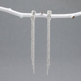 Áine - Cylinder with Chains Silver Earrings - Stud  Design: Four chains of different lengths cascading from the center of the cylinder Cylinder Diameter: 4 MM Total Length: 61 MM from top to bottom Material: Sterling silver with a highly polished finish Fastening: Sterling silver friction post