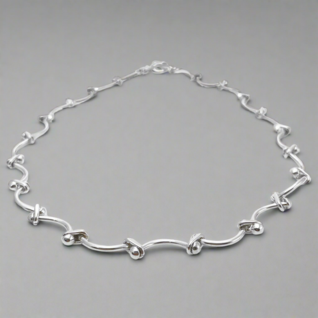 Áine Grace Silver Necklace is a perfect fusion of classic elegance and modern sophistication. Featuring delicately curved bar links accented with double 4 mm beads, this necklace is crafted in high-polished sterling silver to create a timeless, refined look. Ireland jewellry