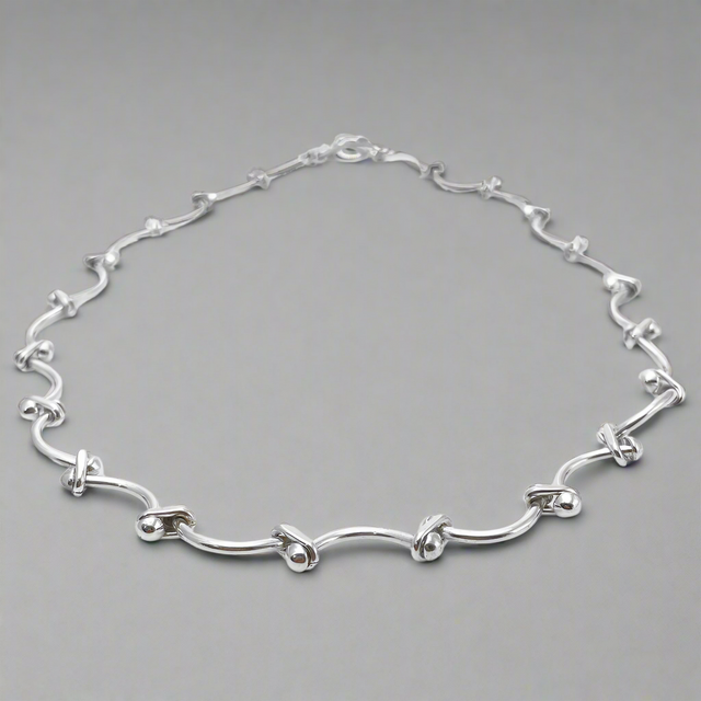 Áine Grace Silver Necklace is a perfect fusion of classic elegance and modern sophistication. Featuring delicately curved bar links accented with double 4 mm beads, this necklace is crafted in high-polished sterling silver to create a timeless, refined look. Ireland jewellry