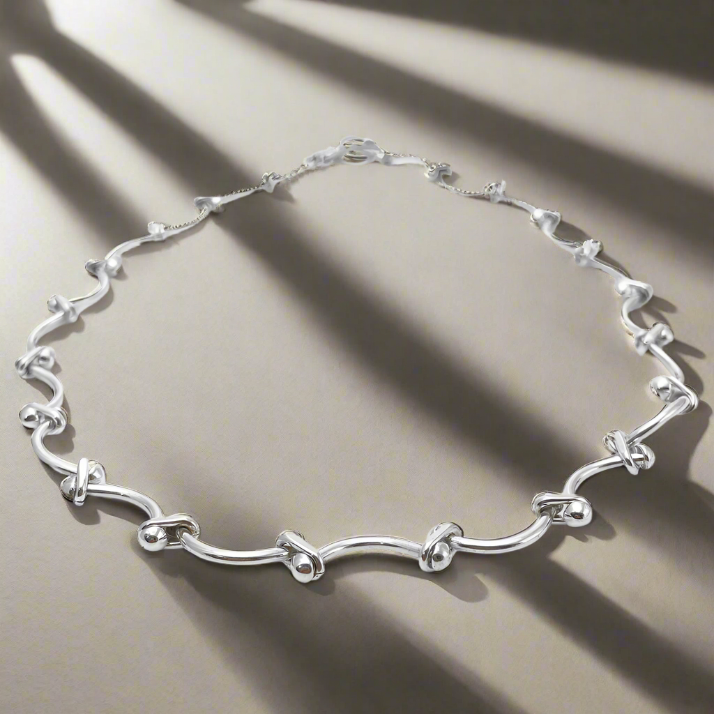 Áine Grace Silver Necklace is a perfect fusion of classic elegance and modern sophistication. Featuring delicately curved bar links accented with double 4 mm beads, this necklace is crafted in high-polished sterling silver to create a timeless, refined look. Ireland jewellery