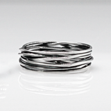 Aran - Lasso S Oxidised Silver Ring. Inspired by lasso rope designs, this piece offers a unique twist to your style.  Crafted with oxidized sterling silver and featuring a comfortable 6mm band width, it's perfect for wearing solo or stacking with other rings to make a statement.