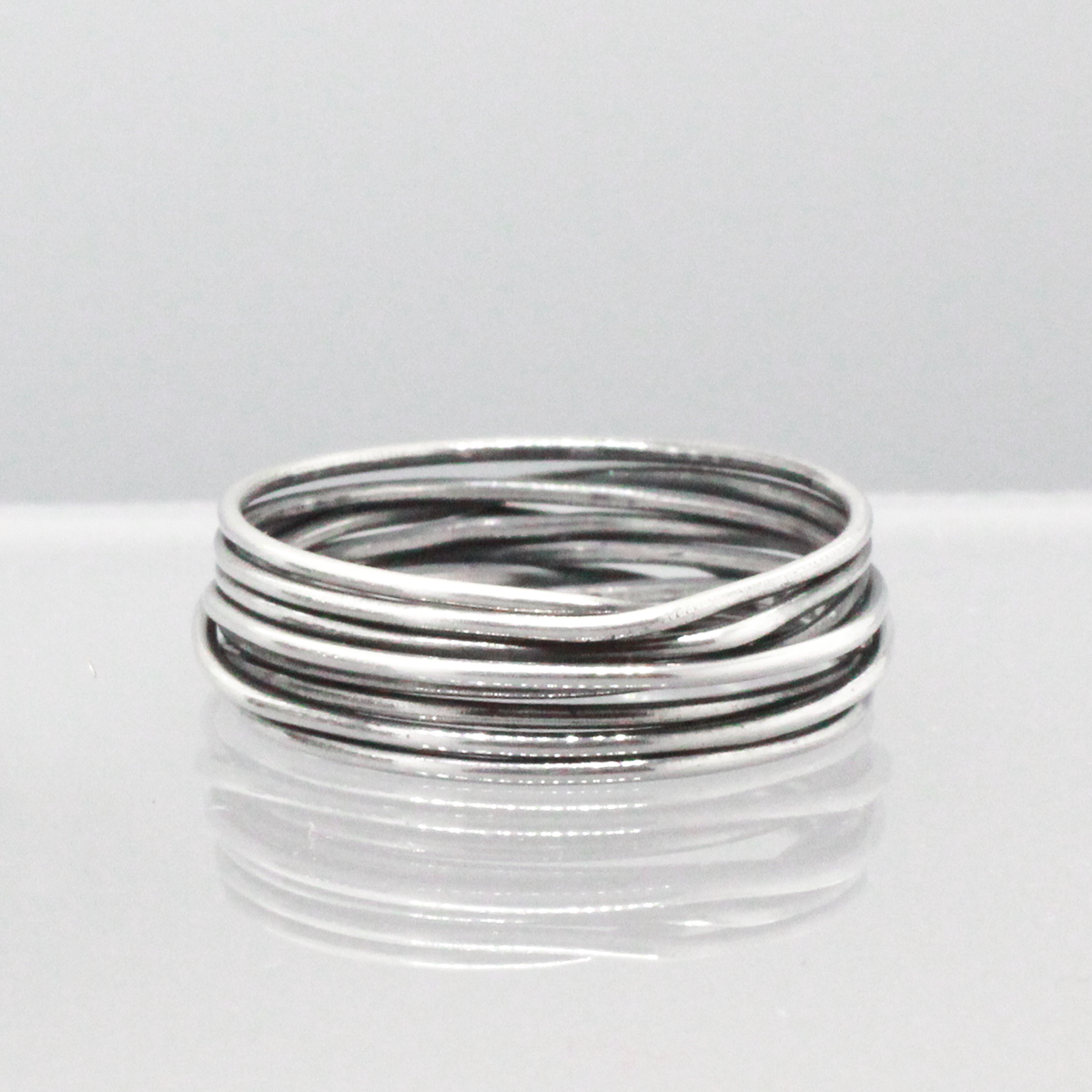 Aran - Lasso S Oxidised Silver Ring. Inspired by lasso rope designs, this piece offers a unique twist to your style.  Crafted with oxidized sterling silver and featuring a comfortable 6mm band width, it's perfect for wearing solo or stacking with other rings to make a statement.