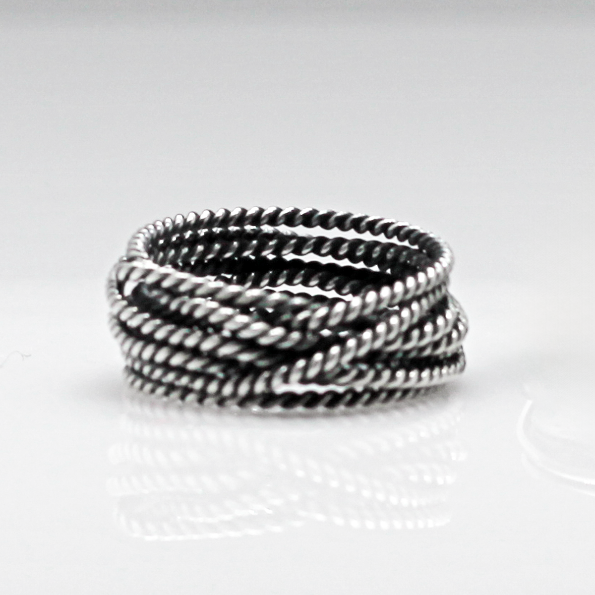 Aran - Twisted Lasso Oxidised Silver Ring. Inspired by the intricate twists of lasso rope designs, this piece adds a unique flair to your style. Crafted from oxidized sterling silver and featuring a comfortable 7mm band width, it's ideal for wearing alone or stacking with other rings for a bold statement.&nbsp;