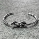 This Aran Thick Infinity Knot Silver Cuff Bracelet is crafted from handmade sterling silver with a highly polished finish. The bold infinity knot design adds a distinctive touch to the piece.

Material: Handmade sterling silver with a highly polished finish
Dimensions:
Thickness: 3.5mm (0.14 inches)
Knot: 12mm wide, 26mm long (0.47 inches wide, 1.02 inches long)
Inside Diameter: 64mm x 43mm (2.5 inches x 1.7 inches)
Cuff Gap: 41mm (1.6 inches)
A sturdy and stylish bracelet that makes a statement with its cl