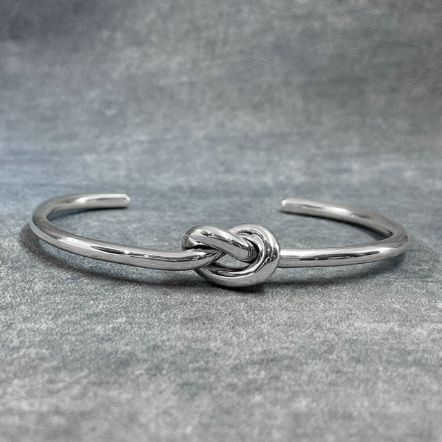 This Aran Thick Single Knot Silver Cuff Bracelet is crafted from handmade sterling silver and features a highly polished finish. The simple yet bold design showcases a single knot, adding a touch of elegance to any wrist.

Material: Handmade sterling silver with a highly polished finish
Dimensions:
Thickness: 3.2mm (0.13 inches)
Knot: 10mm wide, 15mm long (0.4 inches wide, 0.6 inches long)
Inside Diameter: 62mm x 43mm (2.4 inches x 1.7 inches)
Cuff Gap: 31mm (1.2 inches)
A timeless accessory, perfect for ev