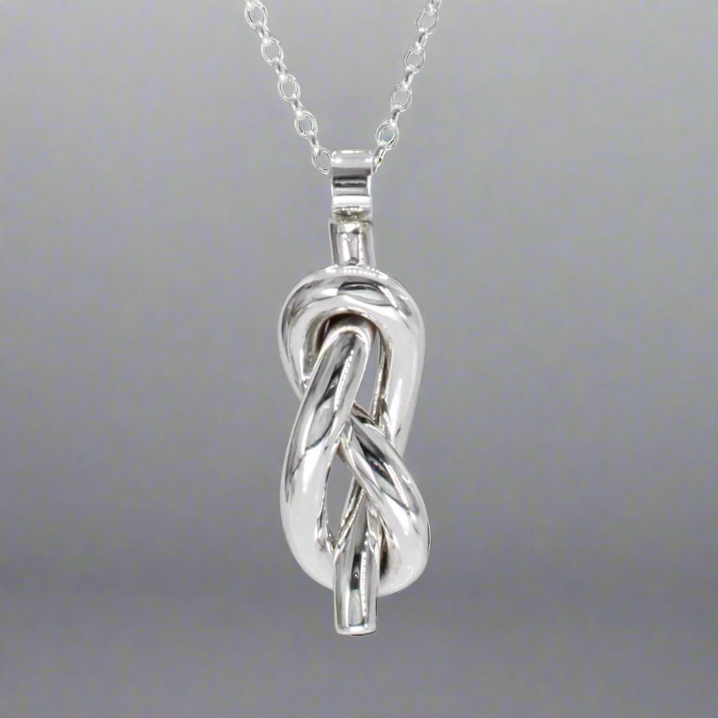 Aran - Single Open Knot Silver Pendant Ireland Jewellery West Cork

Inspired by timeless nautical knots. This sculpted pendant is handcrafted in solid sterling silver. Its open knot design, combined with a highly polished finish, makes it a versatile piece for daily wear or special occasions. Perfect Christmas Gift
Details:
* Material: Handmade solid sterling silver
* Dimensions: 12mm wide x 34mm high (from the top of the bail) x 8mm thick (approx. 1/2" x 1 3/8" x 5/16")
