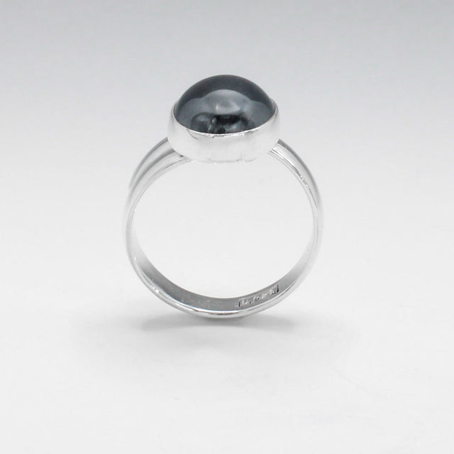 Candy - Oval Hematite Cabochon Silver Ring - Adjustable. Jewellery shop ireland.Hematite typically has a metallic gray to black colour with a shiny, reflective surface, giving it a distinctive, mirror-like appearance. The stone has a high metallic luster. Traditionally, hematite is believed to have grounding and protective qualities, often used in metaphysical practices to enhance focus, courage, and balance.