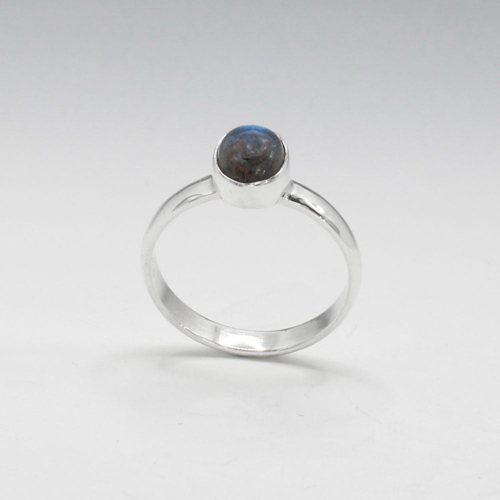 Labradorite is a captivating gemstone known for its unique optical properties. Labradorite is famous for its iridescence, often displaying a stunning play of colours, known as labradorescence. Candy - Small Oval Labradorite Cabochon Silver Ring. Ireland jewellery.