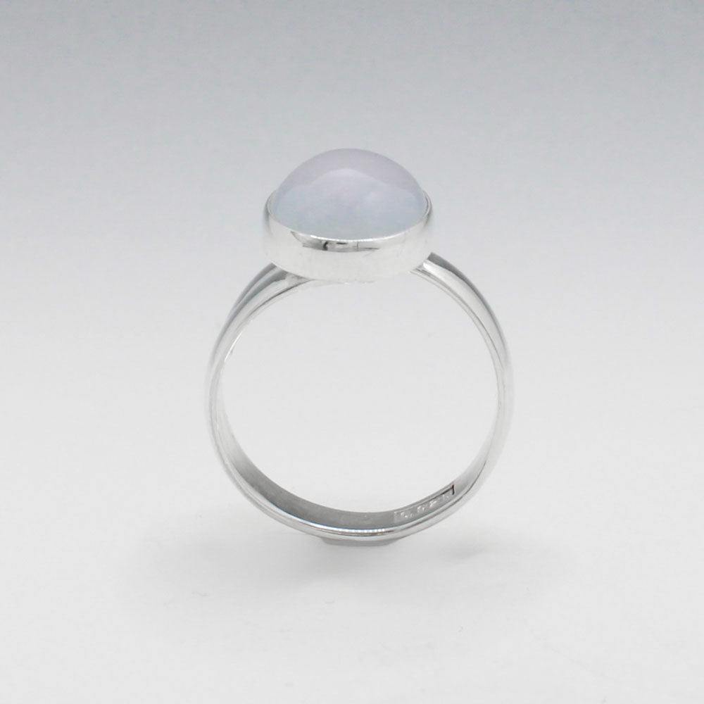 This exquisite ring features an oval blue chalcedony stone with a delicate light pink hue, set in high-quality sterling silver. The cabochon cut highlights the gemstone's natural beauty, while the adjustable band ensures a perfect fit for any wearer. This elegant piece adds a touch of sophistication and color to any outfit. Silver jewellery shop Ireland.