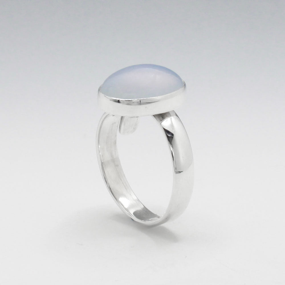 This exquisite ring features an oval blue chalcedony stone with a delicate light pink hue, set in high-quality sterling silver. The cabochon cut highlights the gemstone's natural beauty, while the adjustable band ensures a perfect fit for any wearer. This elegant piece adds a touch of sophistication and color to any outfit. Silver jewellery shop Ireland.