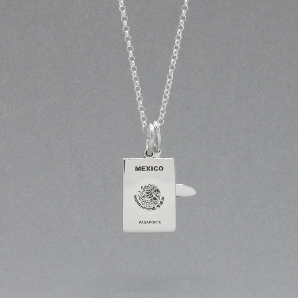 Our Mexican Passport Mini Replica Silver Pendant captures the intricate details of a Mexican passport cover, meticulously crafted from sterling silver with a high-polished finish.  Dimensions: Passport: 10mm wide by 14mm high; Airplane: 14mm wide by 14mm high. Bail: Fits up to a 2.5mm chain for versatile wear. Chain: Includes a 1.4mm sterling silver belcher Rolo chain, available in various lengths.